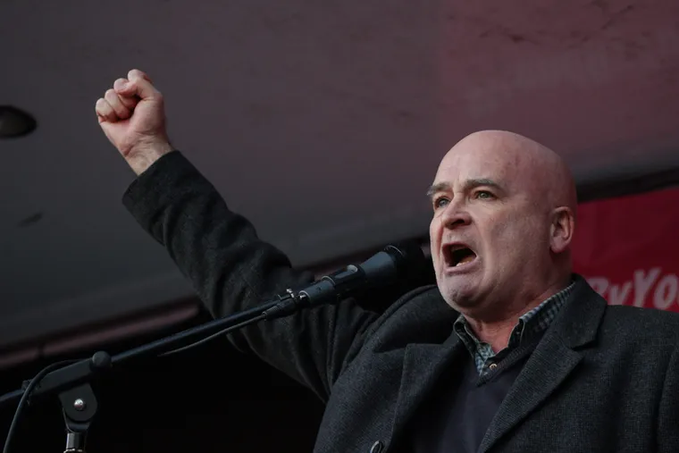 Mick Lynch making a speech with his right hand raised